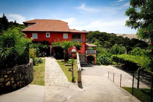 a red house with a pathway in front of it at Apartments in Lopar - Insel Rab 36282 in Lopar