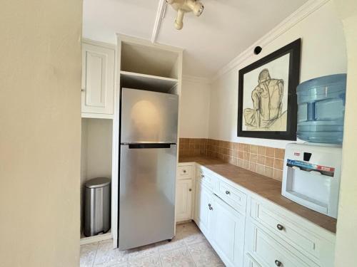 a kitchen with a stainless steel refrigerator and cabinets at Hornbill Cottage in Nairobi