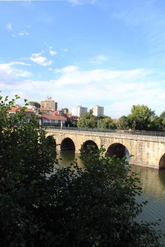 a bridge over a river with a city in the background at Casa do Rio in Chaves
