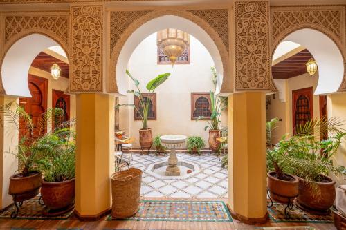 a courtyard with a fountain and potted plants at Riad Amalia in Marrakesh