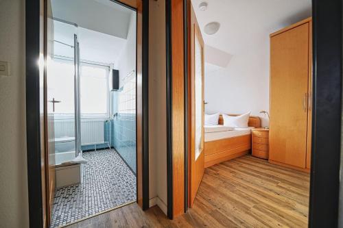 a bathroom with a shower and a bed in a room at Appartement-8 in Süddorf