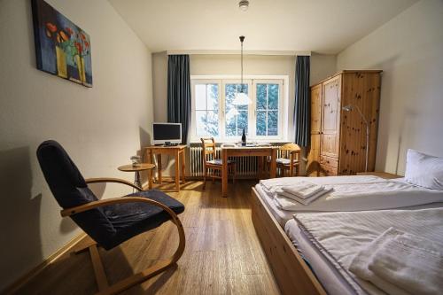 a bedroom with a bed and a chair and a desk at Appartement-4 in Süddorf