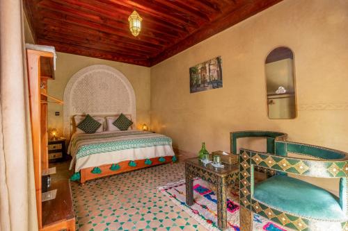 a bedroom with a bed and a table and a chair at Riad Amalia in Marrakesh