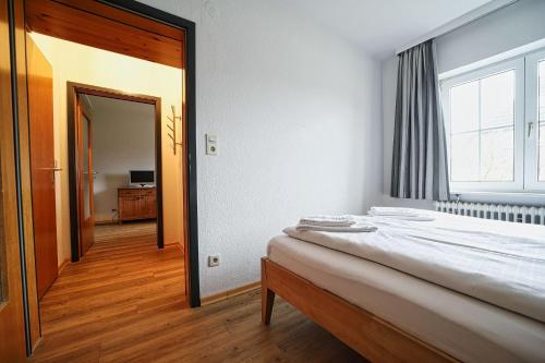a bedroom with a bed and a large window at Appartement-3 in Süddorf