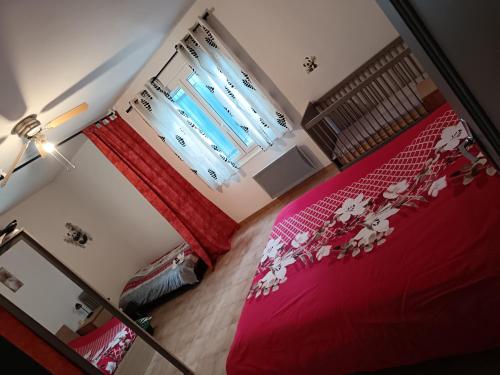 a bedroom with two beds with red sheets and a lamp at L'Escale Pernoise, 2-6 personnes in Pernes-les-Fontaines