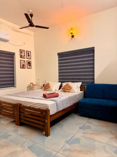a bedroom with a bed and a blue couch at hello 6 cliff stay varkalacliff - cozy rooms , couple friendly ,family ,group rooms in Varkala