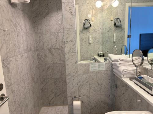 a bathroom with a shower and a toilet and a sink at Montra Odder Parkhotel in Odder