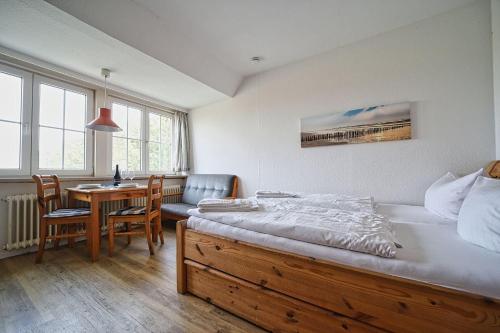 a bedroom with a bed and a desk and a table at Appartement-6 in Süddorf