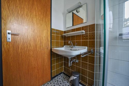 a bathroom with a sink and a glass door at Appartement-7 in Süddorf