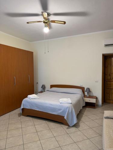 a bedroom with a bed and a ceiling fan at Luciana House in Olbia