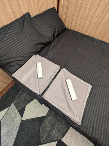 a bed with two pillows on top of it at The G Residence in Calatagan