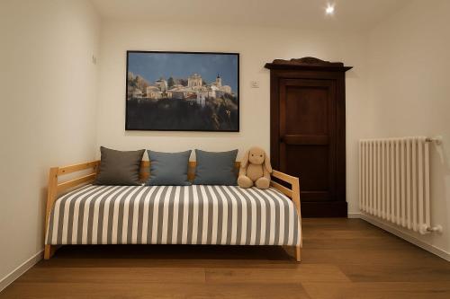 a teddy bear sitting on a bed in a room at CA' VARADE di Martina Scarduelli in Varallo