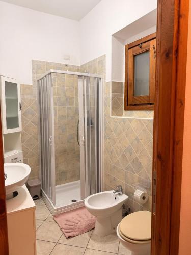 a bathroom with a shower and a toilet and a sink at Luciana House in Olbia