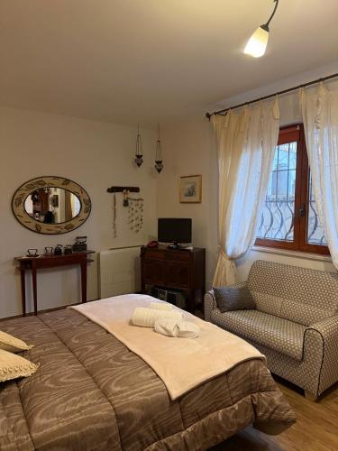 a bedroom with a bed and a chair and a mirror at Liguorini House in Avellino