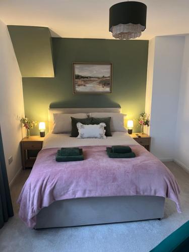 a bedroom with a large bed with a purple blanket at 60 Springfield Road in Stornoway