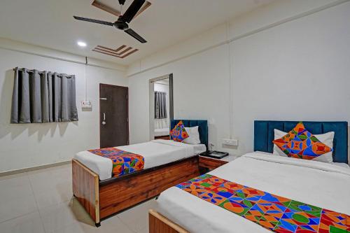 a bedroom with two beds and a ceiling fan at FabHotel Pearl Inn in Pune