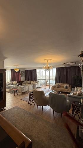a large living room with couches and a chandelier at Apartment on the Nile, 3 bedrooms and a living room in Cairo