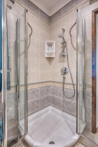 a bathroom with a shower and a tub at Stunning 2BR Villa with Pool in Mġarr