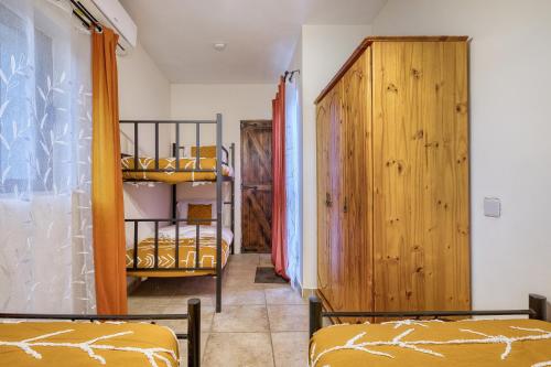 a room with two beds and a wooden closet at Stunning 2BR Villa with Pool in Mġarr