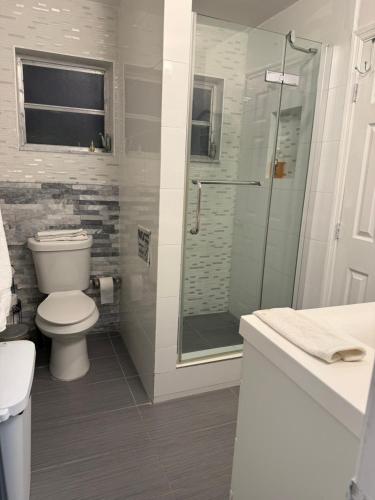 a bathroom with a toilet and a glass shower at My Help Comes from The Lord Miami in Palmetto Bay