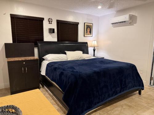 a bedroom with a large bed with a blue blanket at My Help Comes from The Lord Miami in Palmetto Bay