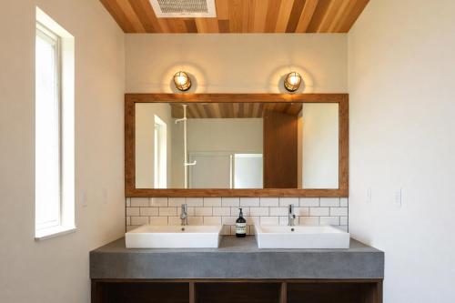 a bathroom with two sinks and a mirror at The Lake House 野尻湖 in Shinano