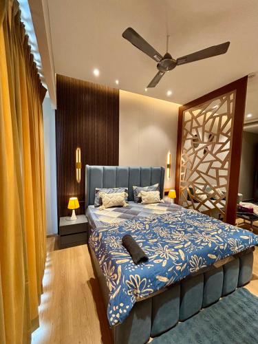 a bedroom with a bed with a blue comforter at Sky High Nest Noida in Ghaziabad