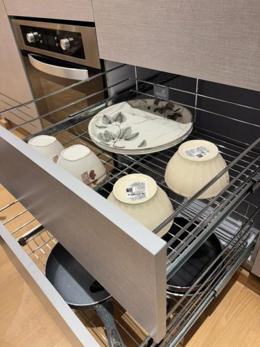 a dishwasher with dishes and plates in it at Sky High Nest Noida in Ghaziabad