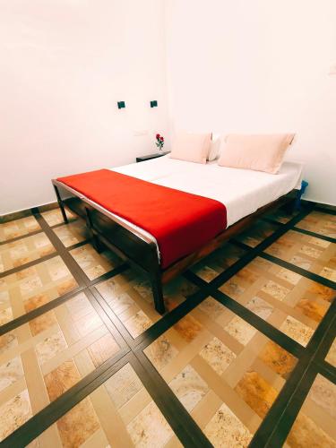 a bed in a room with a red blanket at Marari Jose Villas in Mararikulam