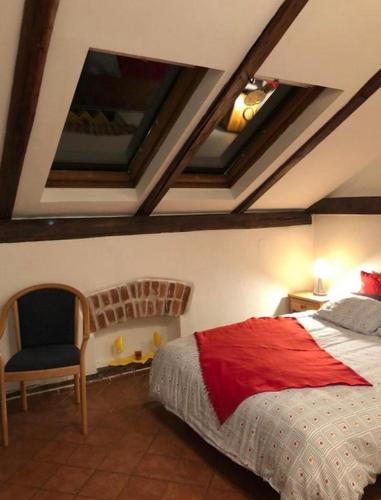 a bedroom with a bed and a chair at Na Mahlerce in Jihlava