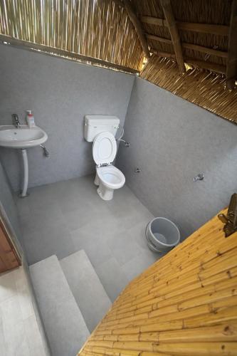 a bathroom with a toilet and a sink at Bamboo Life in Dera Gopipur
