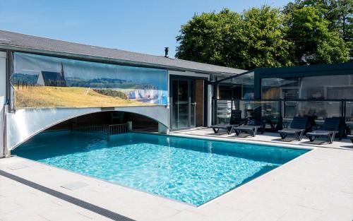 a house with a swimming pool with glass walls at Camping Abijune d'Étretat in Le Tilleul