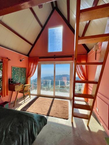 a room with a large window and a stairway at The Mystic Loft in Dharamshala