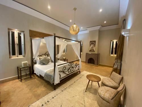 a bedroom with a canopy bed and a chair at Privat Villa in Marrakesch with Pool & Garten in Marrakesh