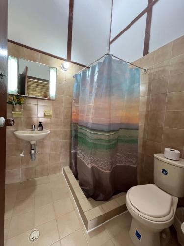 a bathroom with a shower with a toilet and a sink at Villa Del Viento in Calima