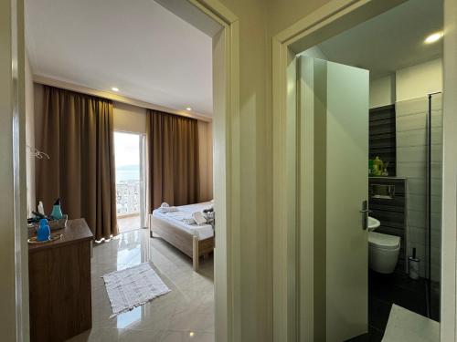 un bagno con doccia e una camera da letto con letto di Light Apartment a Sarandë