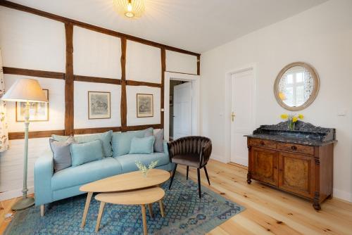 a living room with a blue couch and a table at Brauhaus am Schloss in Gartow