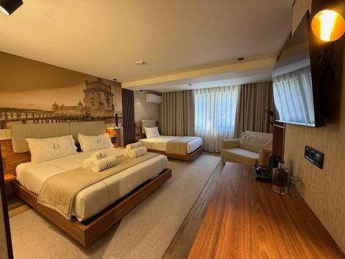 a large hotel room with two beds and a couch at Dom João Glamour Hotel in Lisbon