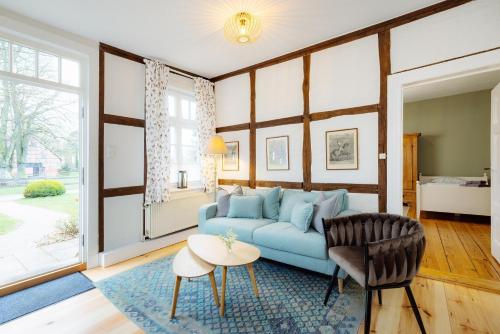 a living room with a blue couch and a table at Brauhaus am Schloss in Gartow