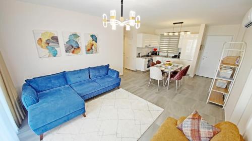 a living room with a blue couch and a kitchen at Thalassa Beach Resort - 107 in Vokolidha