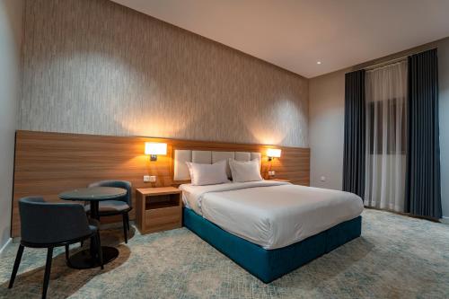 a hotel room with a bed and a table and chairs at Nozol Tabba in Medina