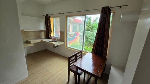 a empty room with a table and a window at Eagle's Nest Inn in Cabangusan