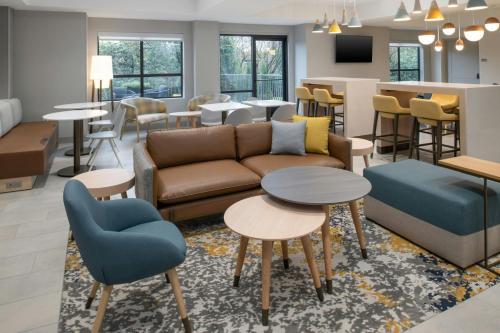a living room with a couch and tables and a bar at TownePlace Suites by Marriott Portland Airport in Portland