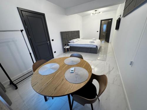 a room with a table and chairs and a bed at PET apartments in Râmnicu Vâlcea
