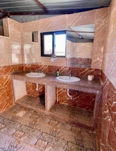 a bathroom with two sinks and a mirror at Wadi Rum Bedouin Story Camp & Tours in Wadi Rum