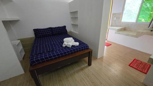 a teddy bear sitting on a bed in a room at Eagle's Nest Inn in Cabangusan