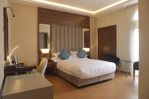 a hotel room with a bed and a desk and a room at Sowirad hotel in Addis Ababa