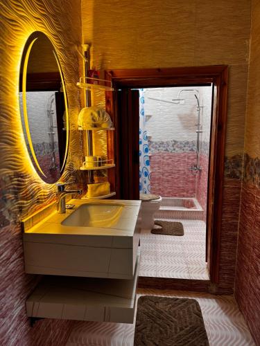 ein Badezimmer mit einem gelben Waschbecken und einem Spiegel in der Unterkunft Salem Guesthouse Experience in Al Ḩayy