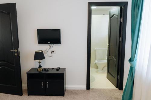 a room with a bathroom with a toilet and a television at Casa Paltinoasa in Păltinoasa