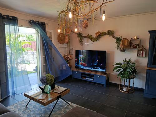 a living room with a tv and a table at Ti ' Jean 4 étoiles in Saint-Joseph